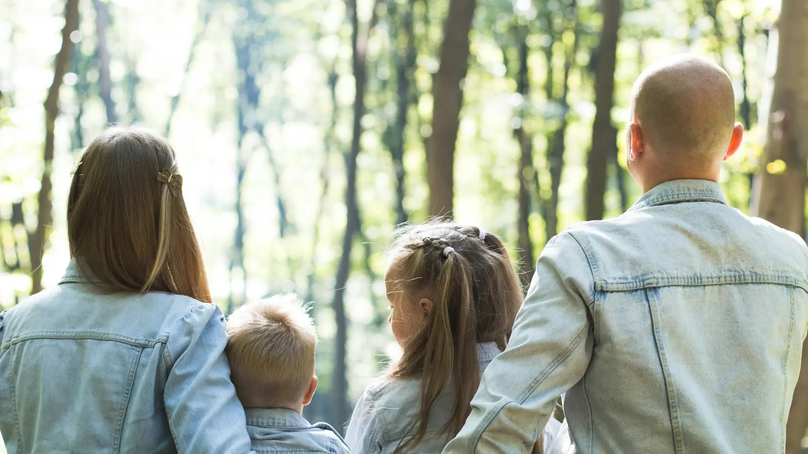 En familj som går tillsammans genom en ljus skog